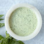 close up of green goddess dressing in white bowl