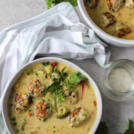two bowls green curry with chicken meatballs