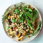 roasted artichoke bean salad on plate with herbs