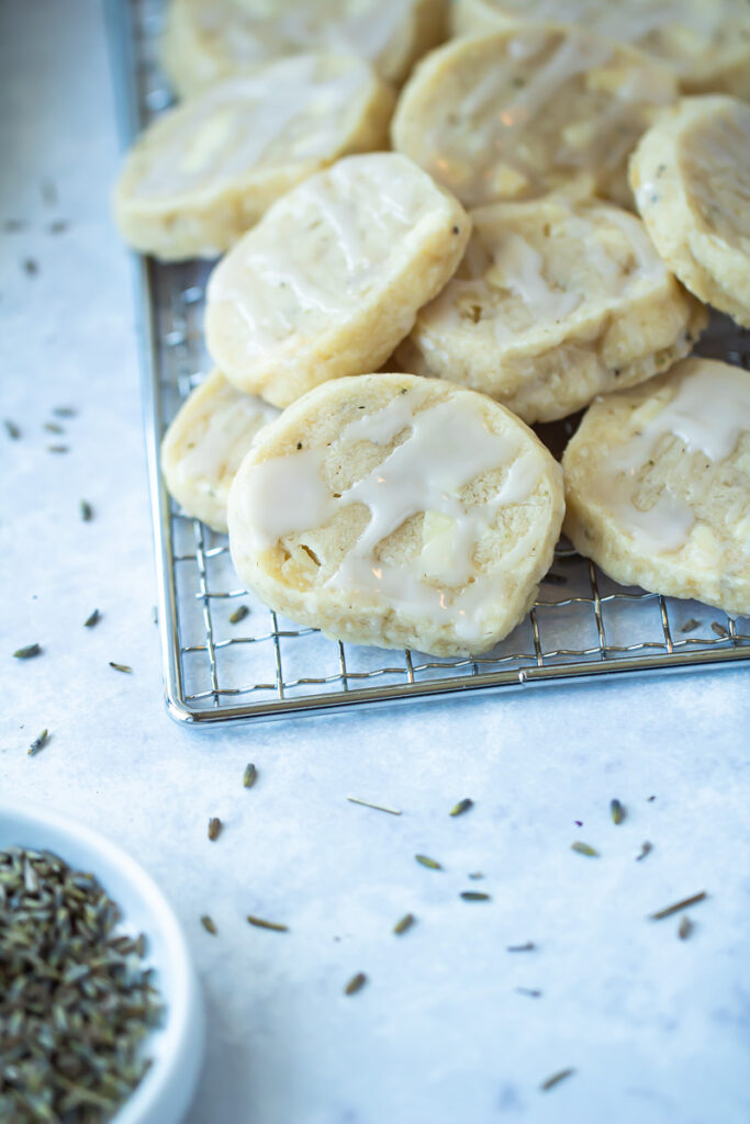 close up of rose glaze on shortbread cookies with lavender in small plate