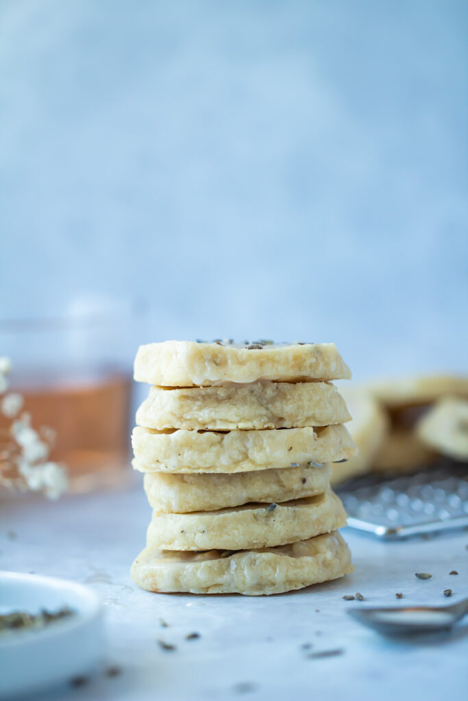stack of lavender shortbread cookies with glass of rose in background
