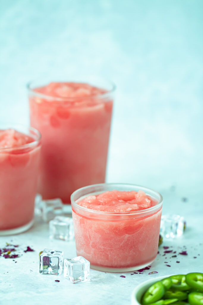 three glasses of spicy watermelon frose and bowl of jalapeno slices