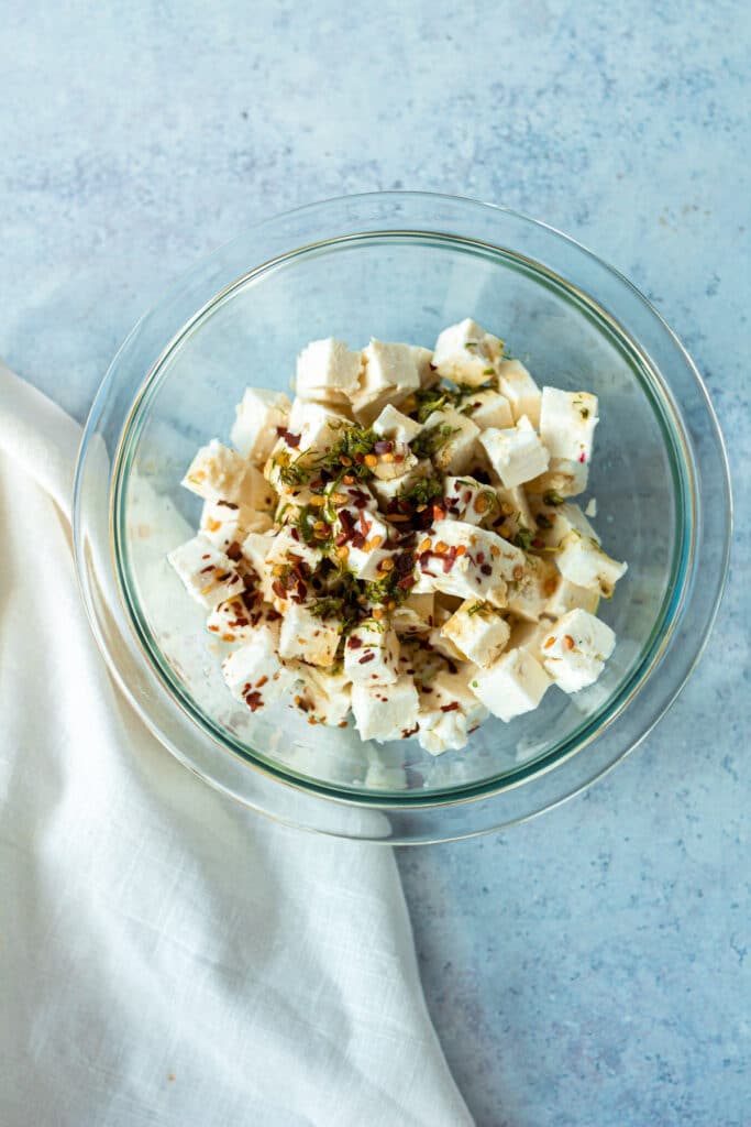 bowl of feta cheese with dressing mixed in