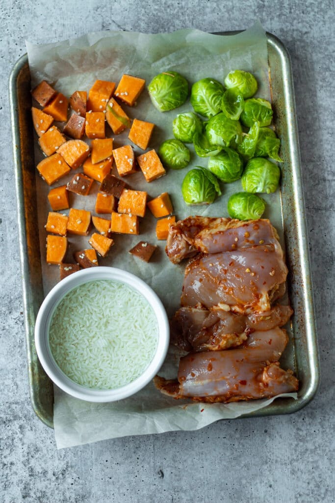 chicken and vegetables on sheet pan before baking