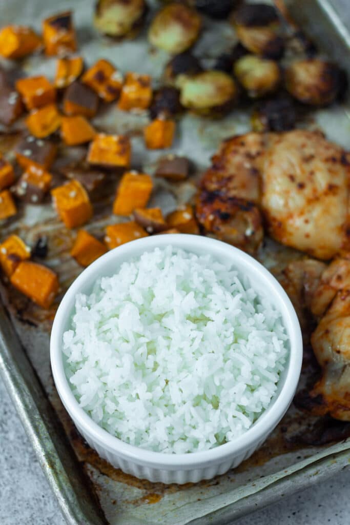 bowl of rice on sheet pan with chicken and vegetables 