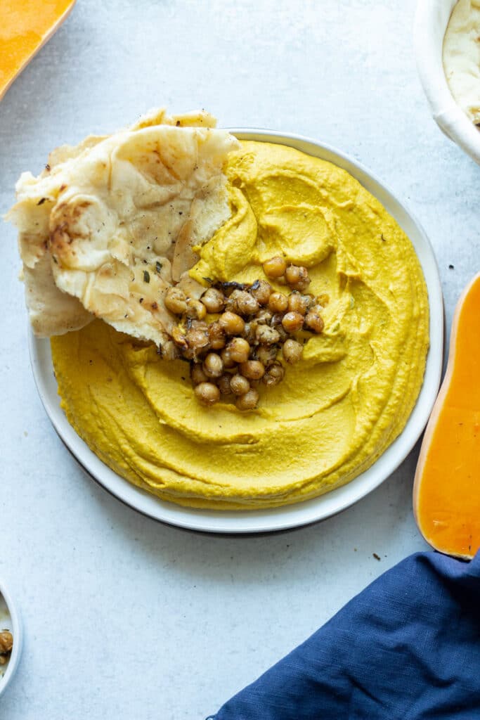 butternut squash hummus with chickpeas on top and pieces of naan