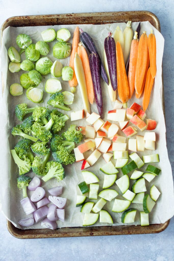 raw, cut up vegetables on sheet pan