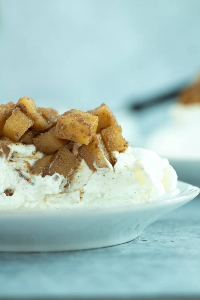 slice of pavlova with whipped cream and apple pie filling