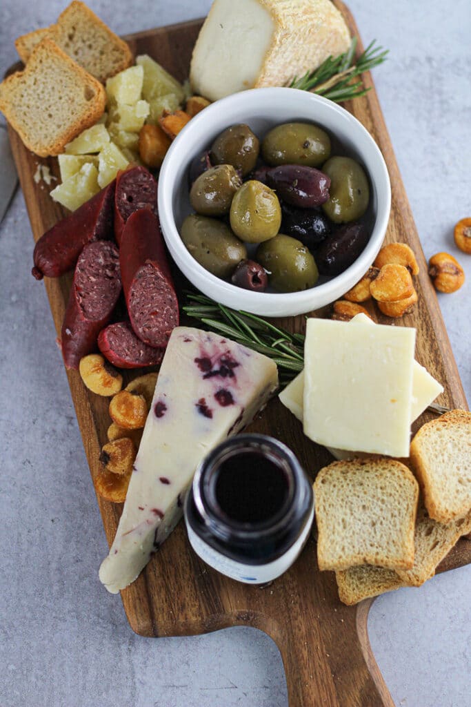 small cheese board with cheese, olives and crackers