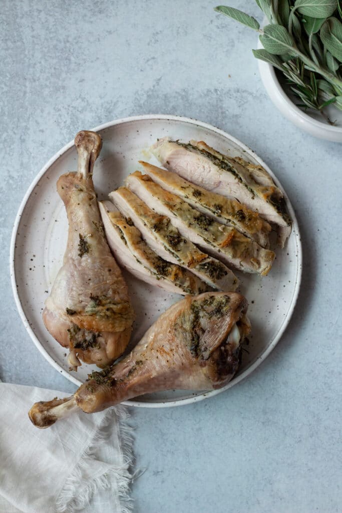 carved turkey breast on plate with drumsticks