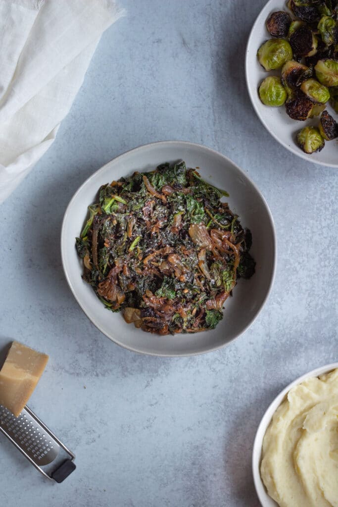 sauted kale with onions and parmesan cheese with thanksgiving side dishes around