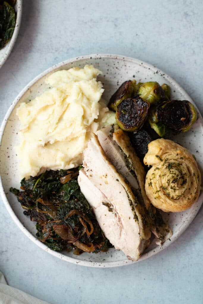 plate of thanksgiving food with mashed potatoes, turkey and brussels sprouts