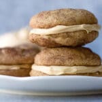 stack of two sandwich cookies on plate with buttercream filling behind plate