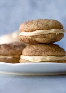 stack of two sandwich cookies on plate with buttercream filling behind plate