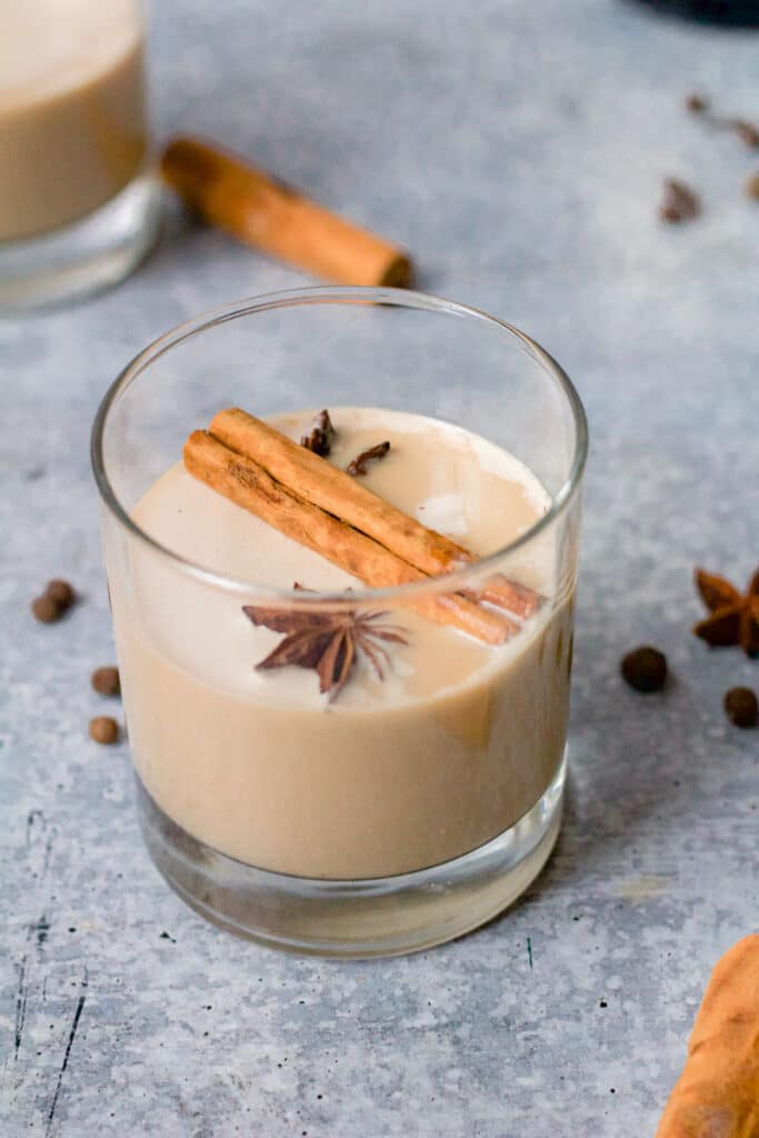 glass of white russian with cinnamon stick and star anise floating on top