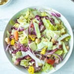 italian chopped salad mixed together in bowl with dressing