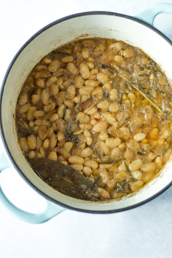 rosemary bacon beans in pot before crispy bacon is put on top