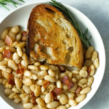 rosemary bacon beans in plate with olive oil toast
