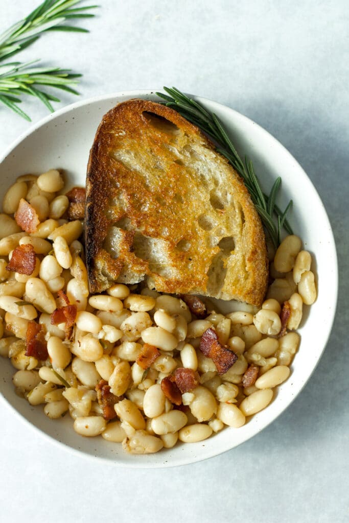rosemary bacon beans in plate with olive oil toast