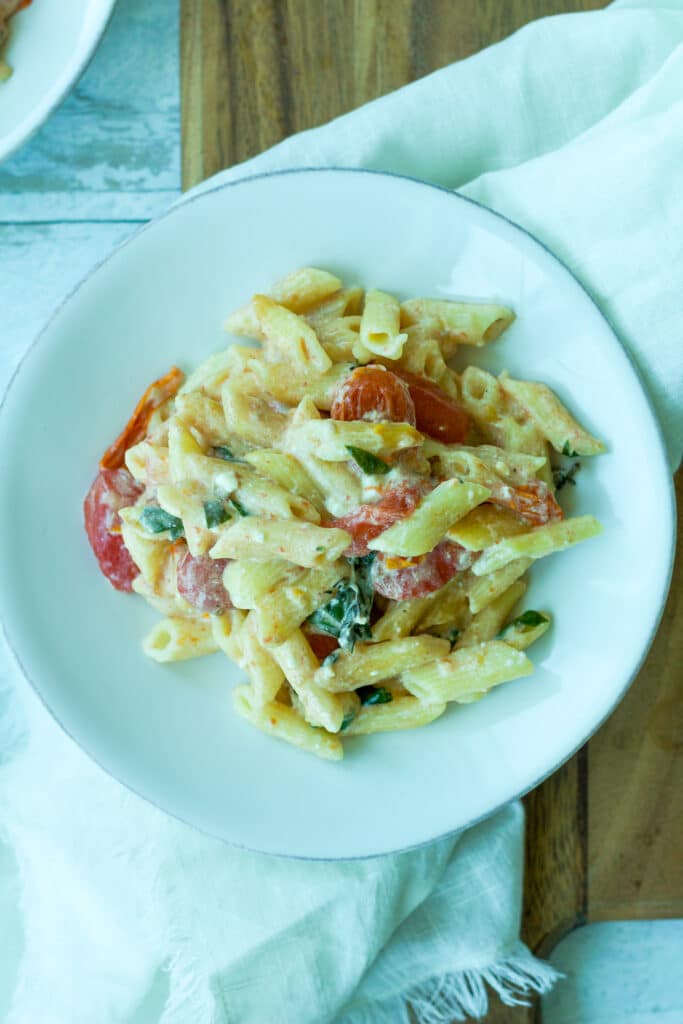 close up shot of tomato and feta pasta on plate