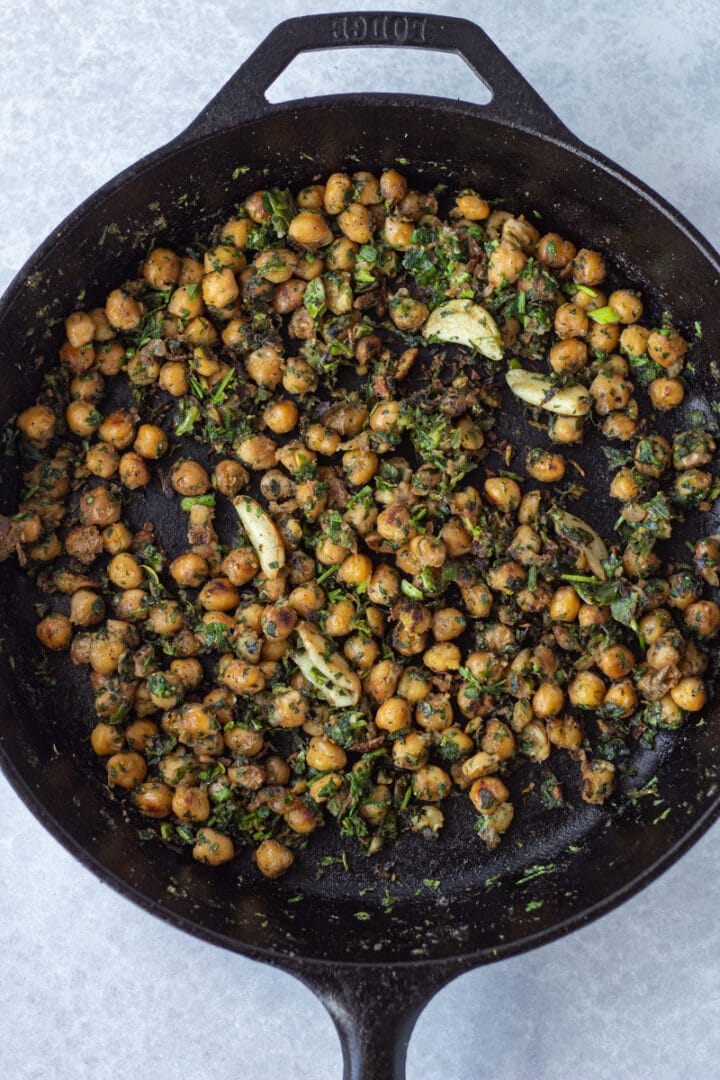 Cast iron pan with crispy chickpeas mixed with garlic and herbs