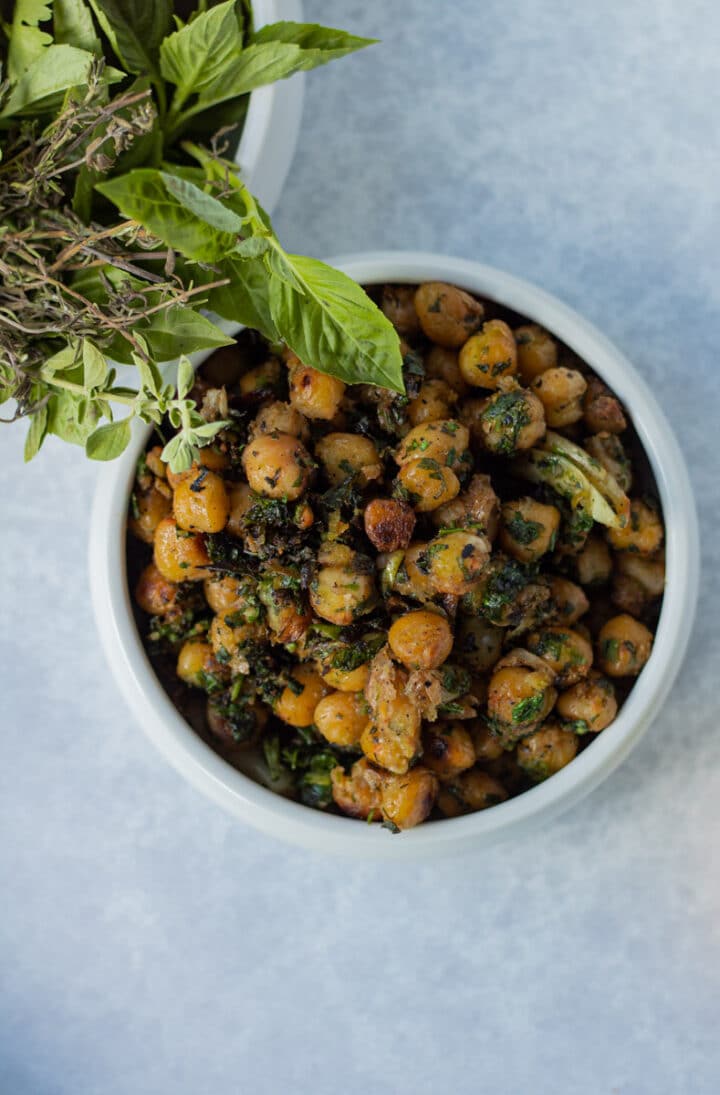 small bowl of pan fried chickpeas with glass of herbs