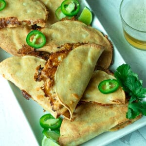 Platter of baked chicken tacos with toppings