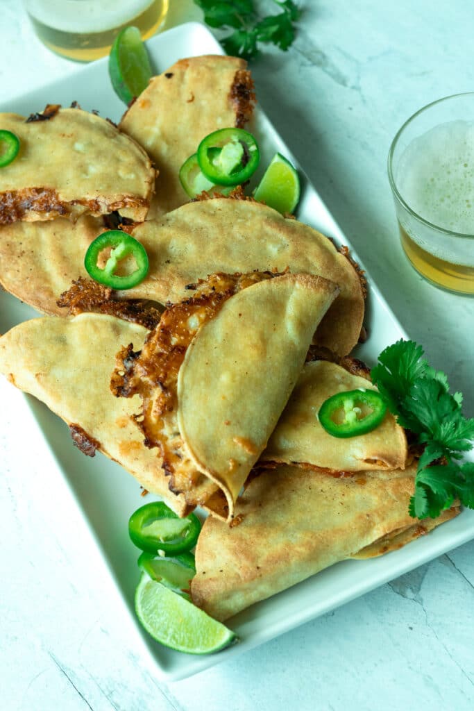 Platter of chicken and caramelized onion tacos with toppings