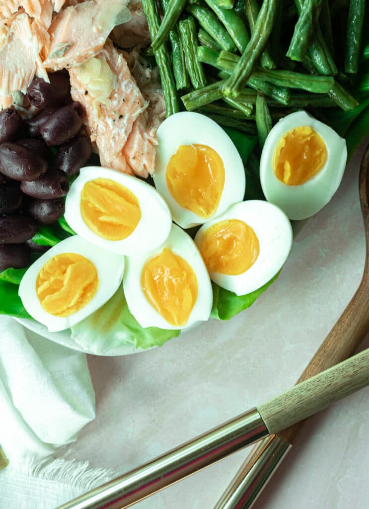 close up of soft boiled eggs in nicoise salad