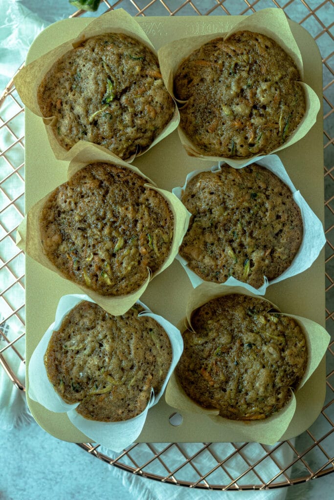 baked muffins in pan on wire rack