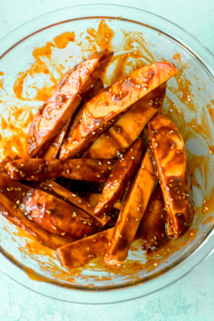 sweet potatoes and marinade combined in mixing bowl