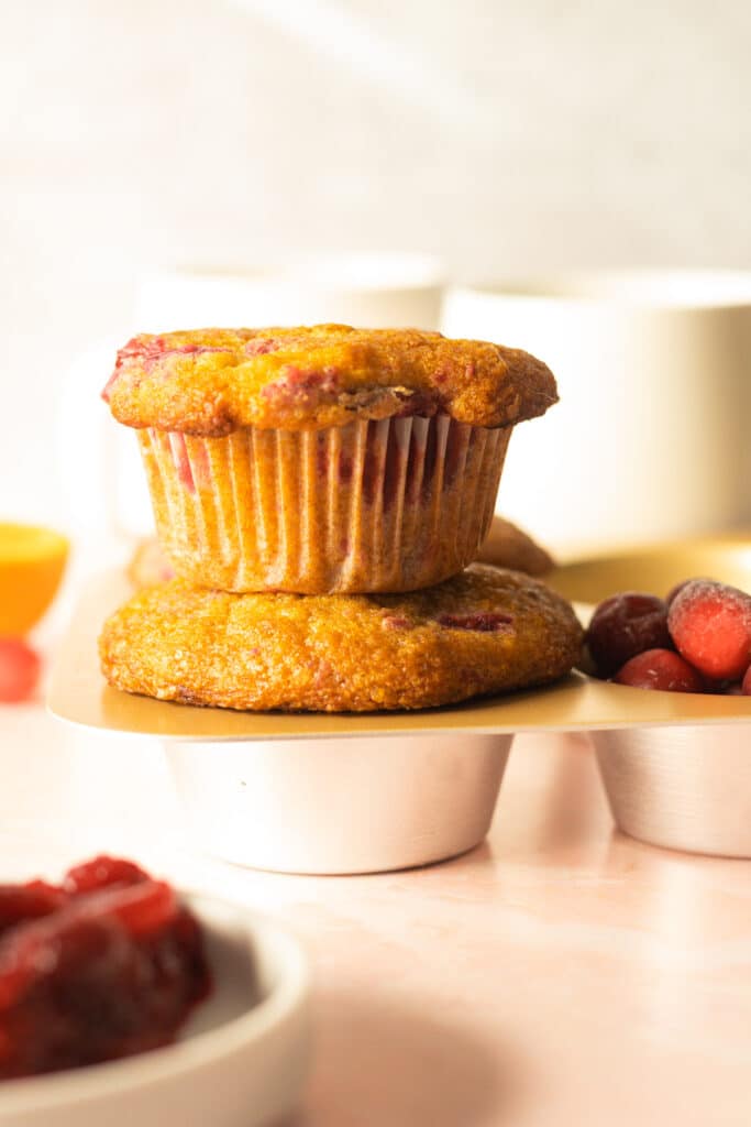 2 cranberry sauce muffins stacked in pan with coffee cups on table