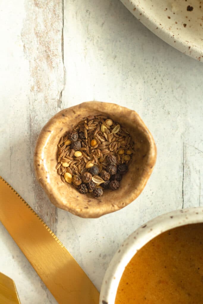 small bowl of whole spices for apple cider chicken marinade