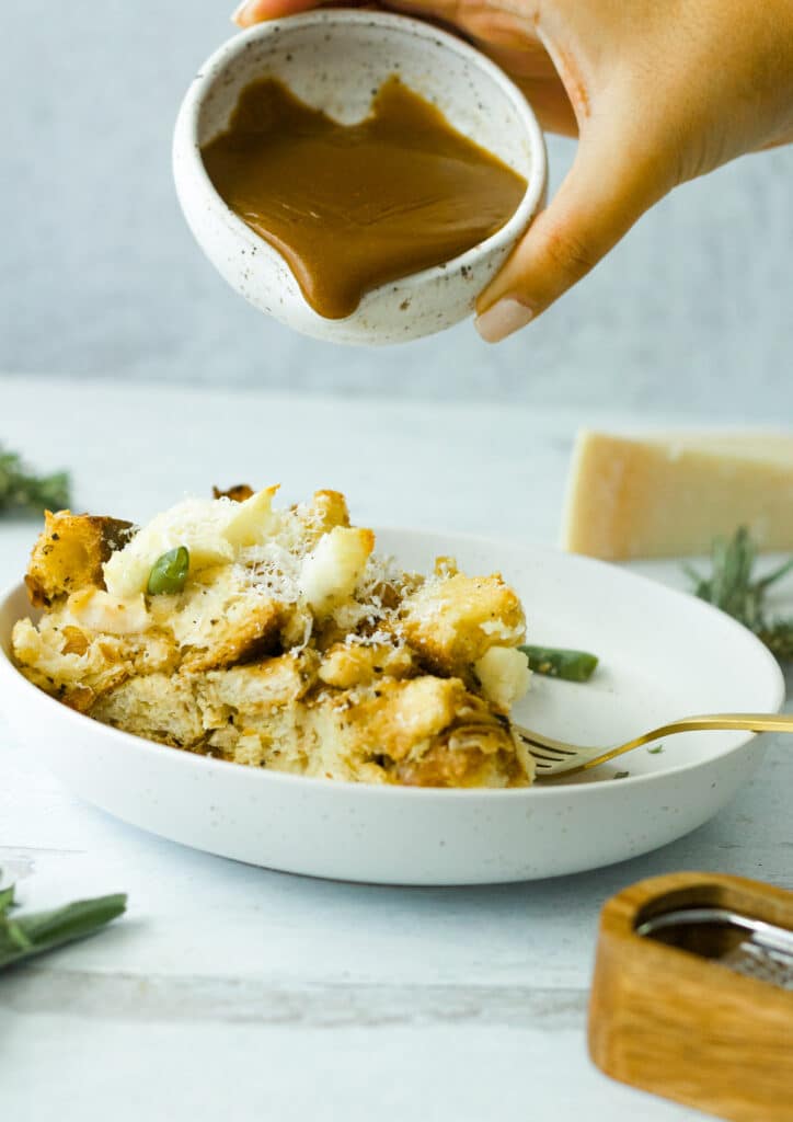 strata on dish with gravy being poured from above