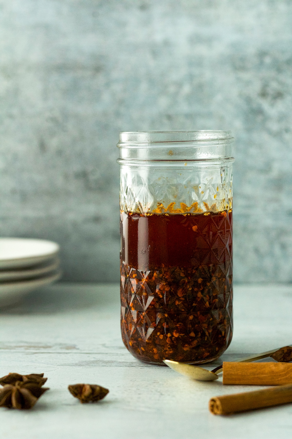 garlic chili oil in glass jar with cinnamon stick and star anise.