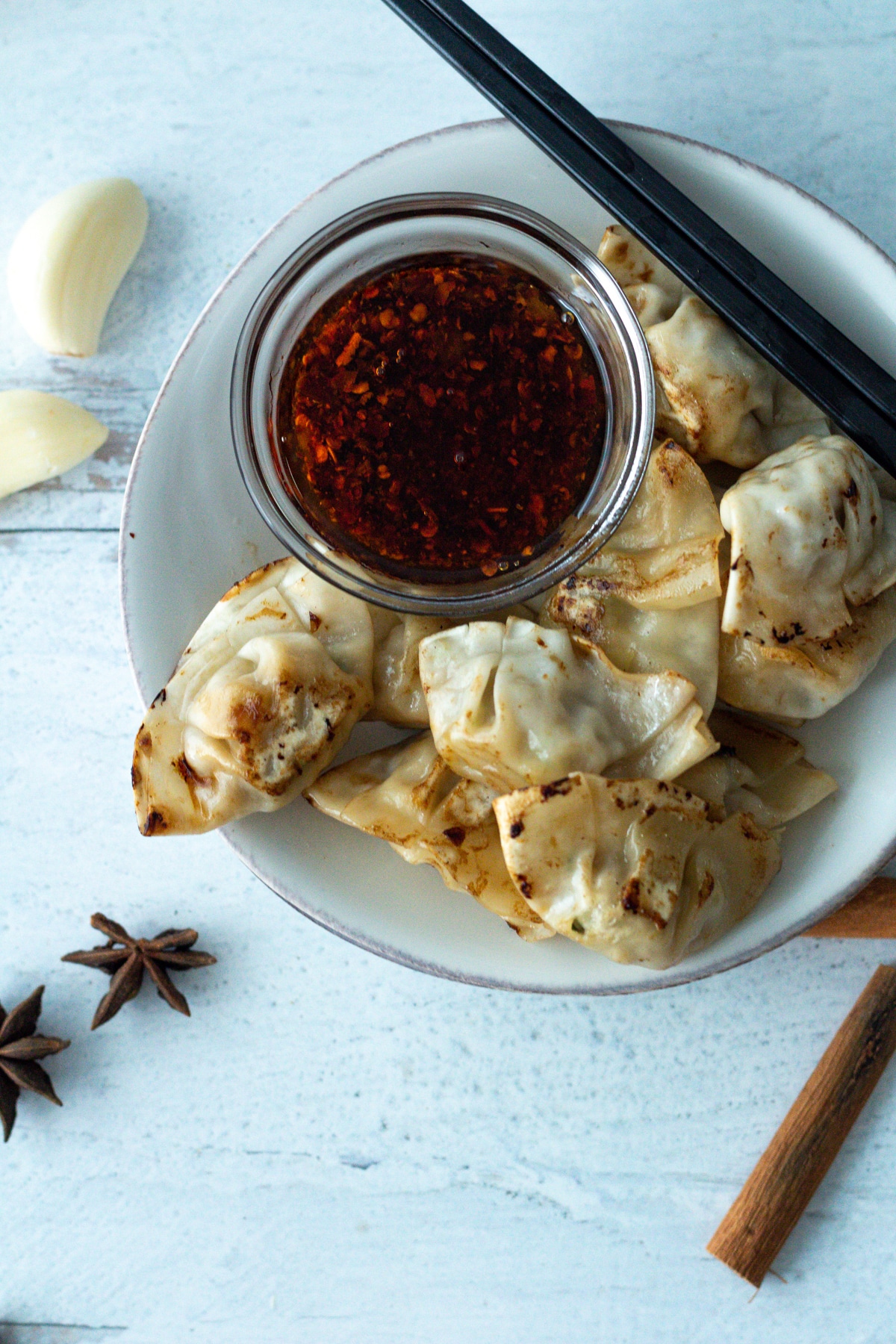 small plate with dumplings and small bowl of chili oil.