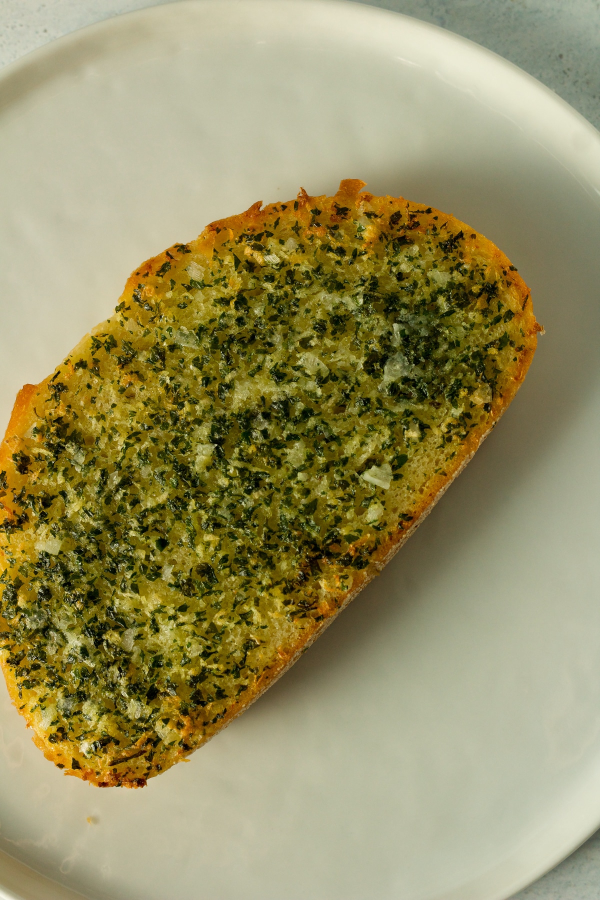 Homemade garlic bread for one on plate.