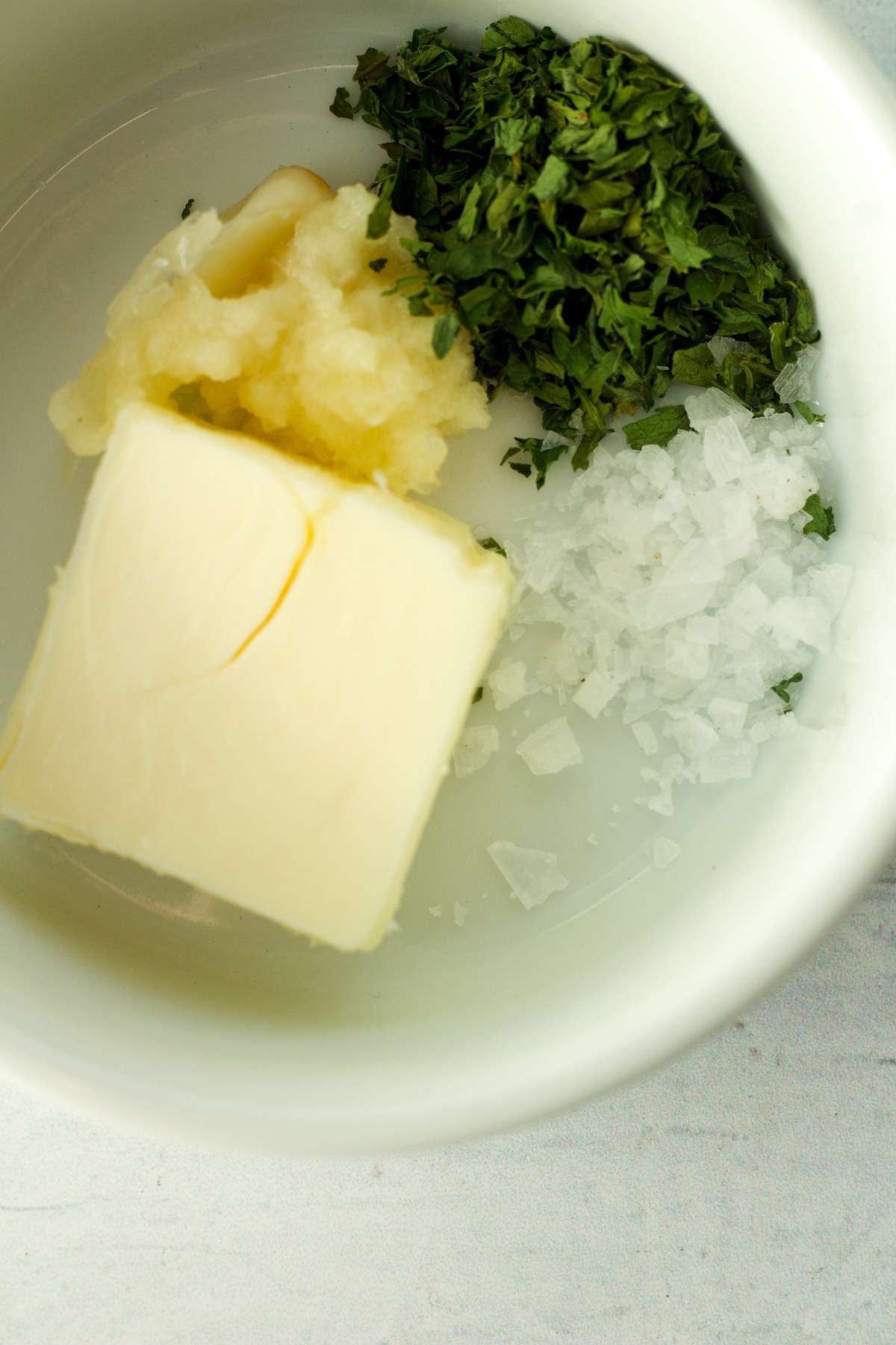 Ingredients for garlic butter in small bowl.