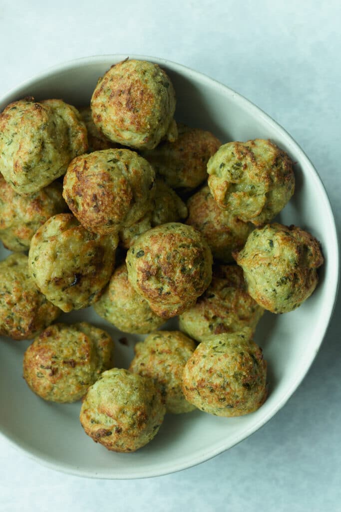 Bowl of cooked pesto chicken meatballs.