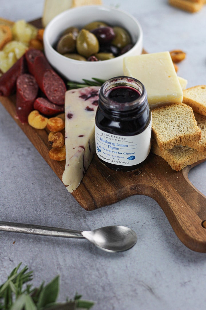 small jam bottle on simple cheese board for two.