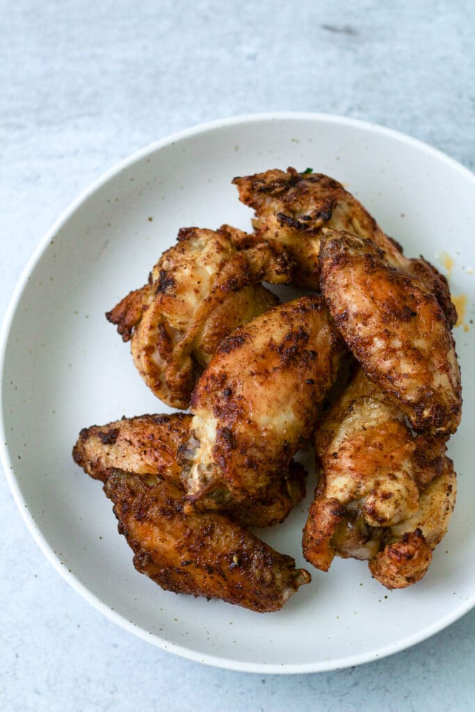 Air fryer frozen chicken wings on plate.