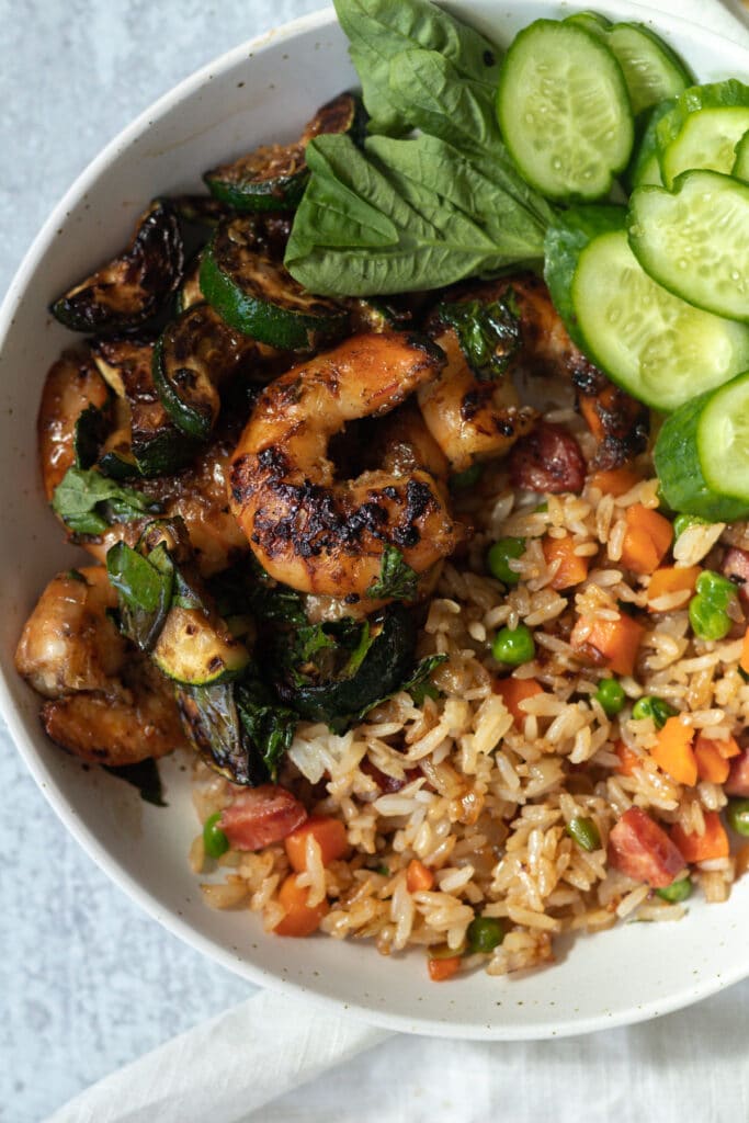 Shrimp stir fry with fried rice on plate.