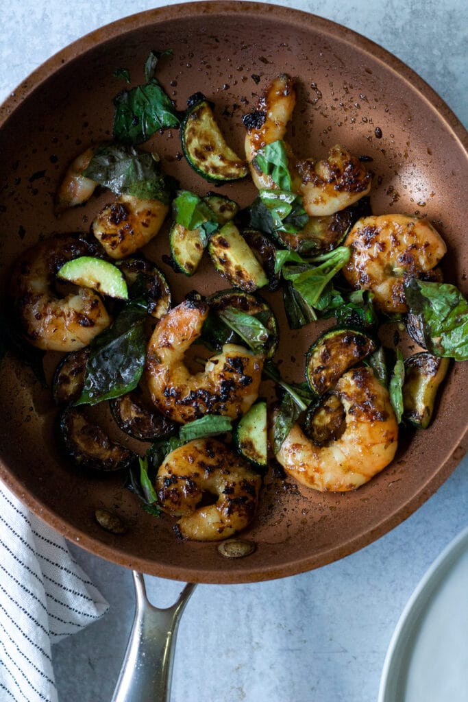 Frying pan with shrimp and basil stir fry.