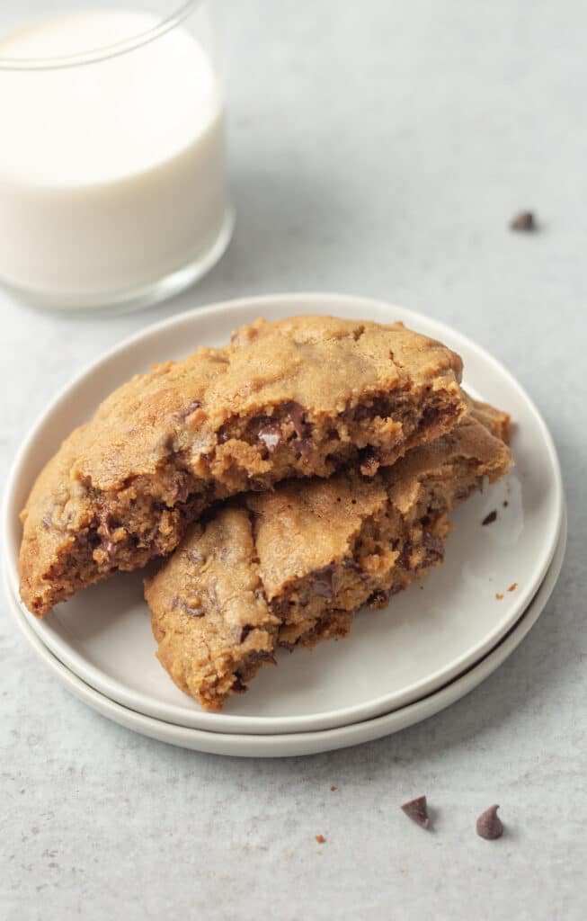 Cut chocolate chip cookie stacked on plate.