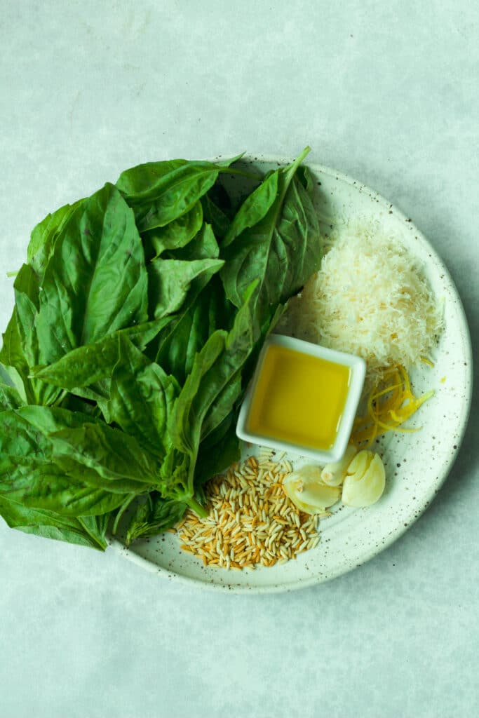 Ingredients to make pesto without nuts on plate.