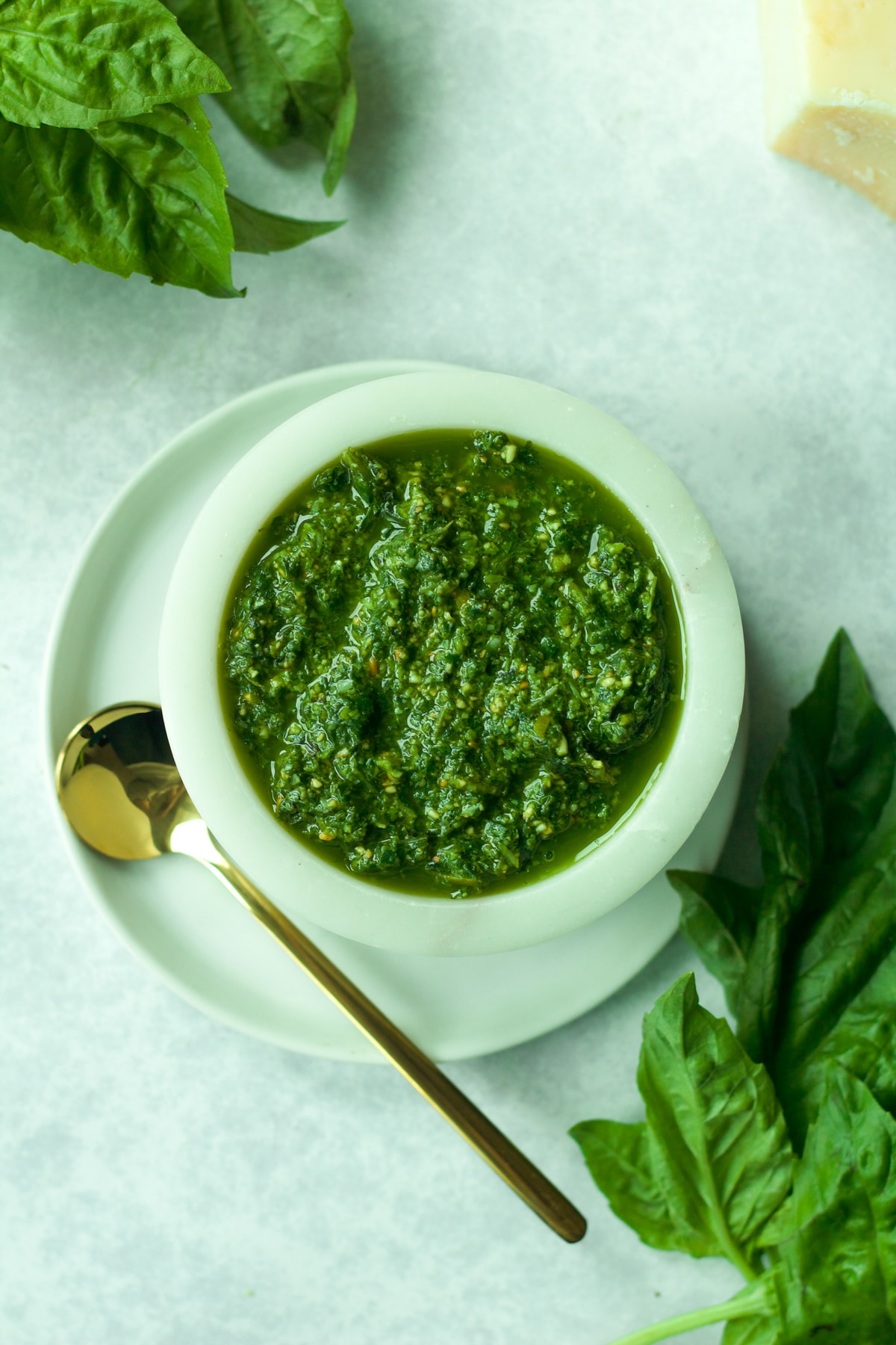 Close up shot of nut-free pesto in bowl with gold spoon.