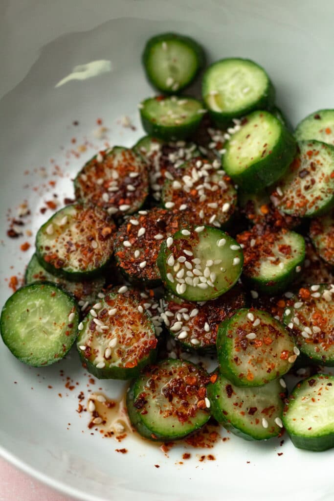 Cucumbers on plate with spices sprinkled on top.