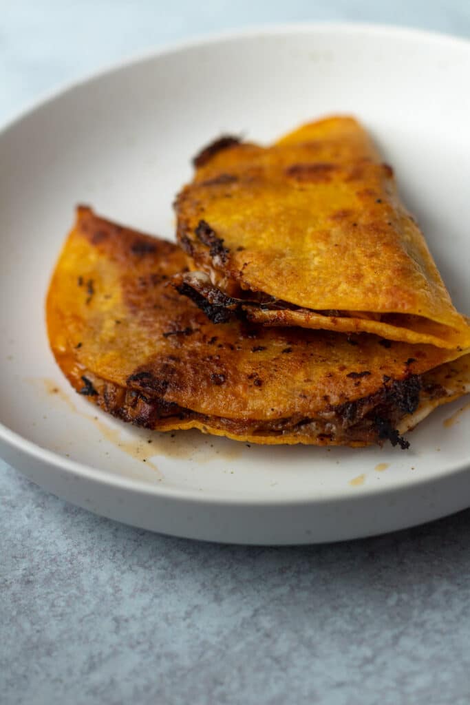 Crispy baked chicken tacos on plate.