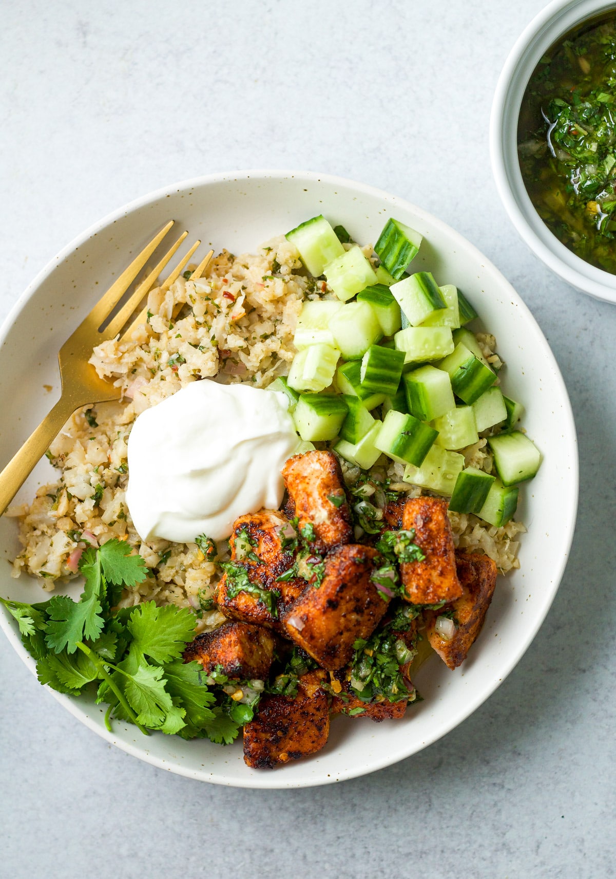 Finished spiced salmon grain bowl on table.