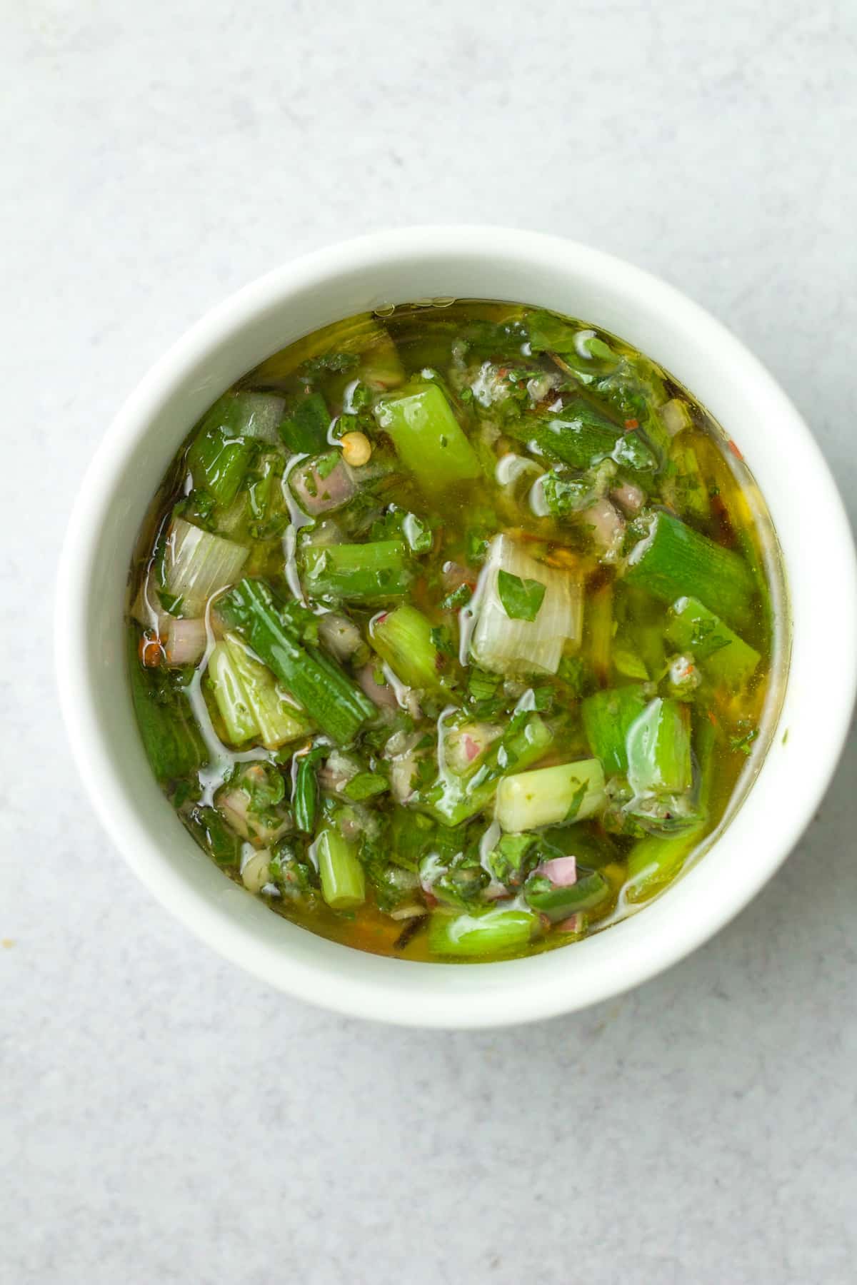 Bowl of grilled scallion chimichurri sauce.